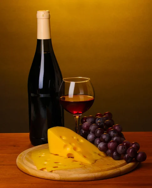 瓶与酒杯和奶酪棕色背景上的木桌上的大酒 — 图库照片