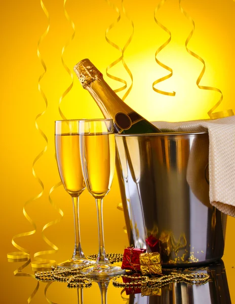 Kova buz ve şampanya, Sarı zemin üzerine bir bardak şampanya şişesi — Stok fotoğraf