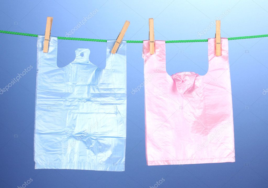 Cellophane bags hanging on rope on blue background