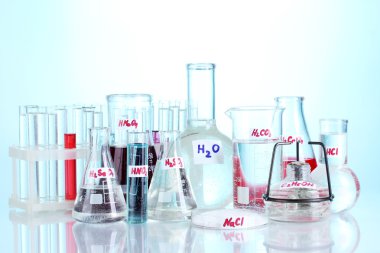 Test-tubes with various acids and chemicals on blue background clipart