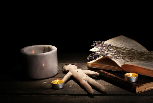 Muñeco vudú en una mesa de madera a la luz de las velas —  Fotos de Stock