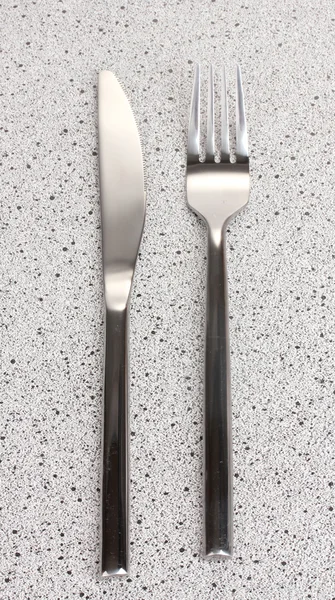 Tenedor y cuchillo sobre mesa de mármol —  Fotos de Stock