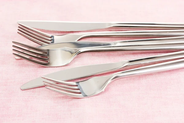 粉色桌布上的刀子和叉子 — 图库照片