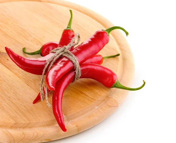 Red hot chili peppers ile ahşap tahta üzerinde beyaz izole ipe bağlı. — Stok fotoğraf