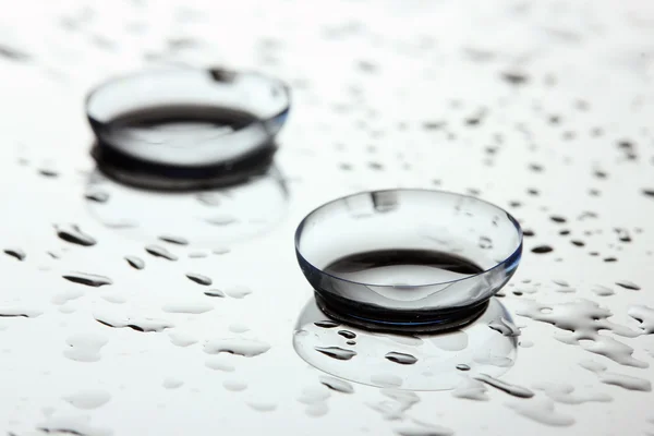 Kontaktlinse mit Tropfen auf weißem Hintergrund — Stockfoto