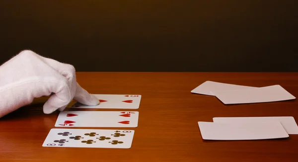 Kártyák és kéz barna alapon — Stock Fotó