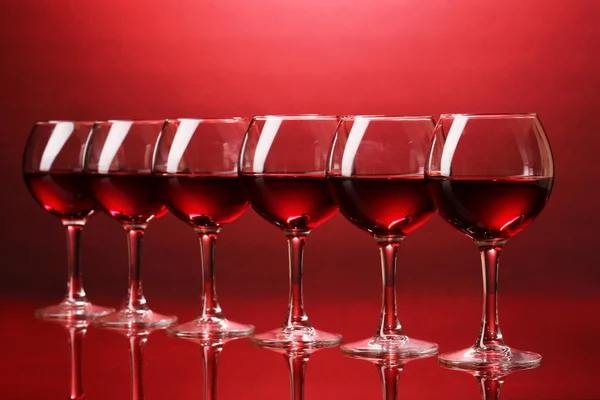 Wijnglazen op rode achtergrond — Stockfoto