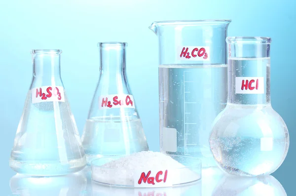 Test tüpleri çeşitli asitler ve mavi zemin üzerine kimyasal madde ile — Stok fotoğraf