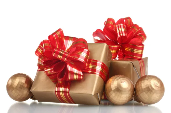 Vackra gyllene gåvor med rött band och julgranskulor isolerad på vit — Stockfoto