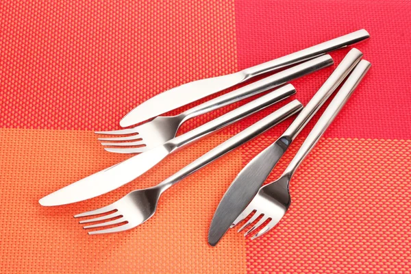 Forchette e coltelli su una tovaglia rossa — Foto Stock