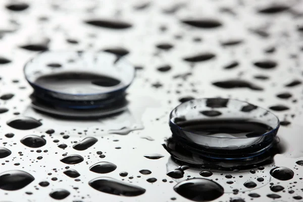 Kontaktlinse mit Tropfen auf grauem Hintergrund — Stockfoto