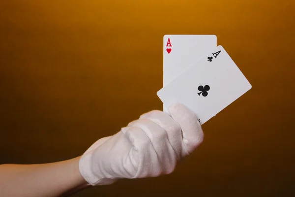 Karty w ręku na brązowym tle — Zdjęcie stockowe