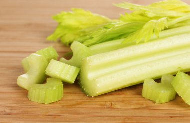 Fresh slised green celery on wooden background clipart