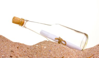 Glass bottle with note inside on sand on white background clipart