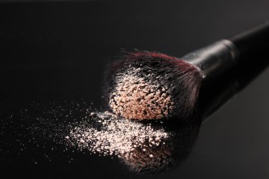 make-up borstel met poeder geïsoleerd op zwart