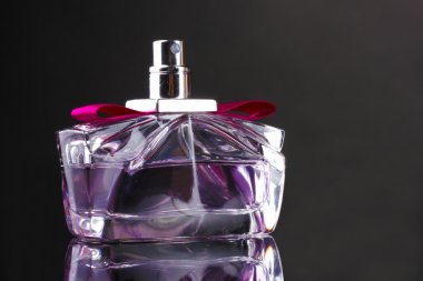 Women's perfume in beautiful bottle on black background clipart