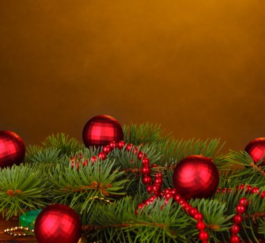 Christmas tree with beautiful New Year's balls on brown background clipart