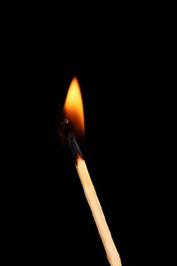 Burning match on black background clipart