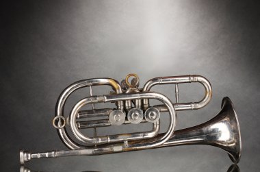 Old trumpet on gray background clipart