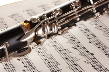 Close up detail of clarinet and notebook with notes clipart