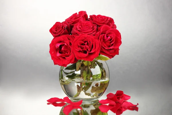 Beautiful red roses in vase on gray background — Stock Photo, Image