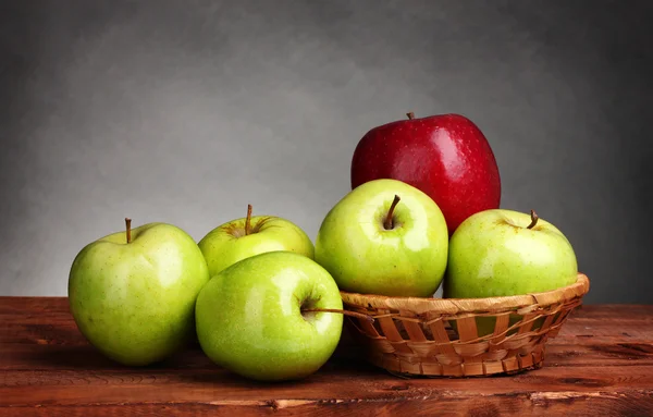Lédús, édes alma kosár, fából készült asztal-szürke háttér — Stock Fotó