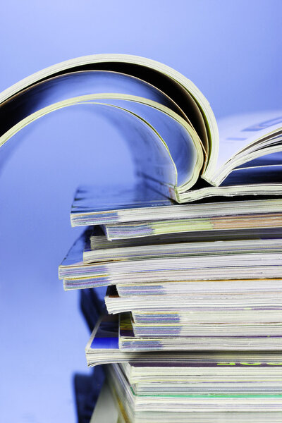 Stack of magazines on blue background