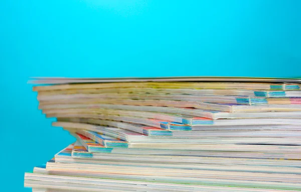 Pila di riviste su sfondo blu — Foto Stock