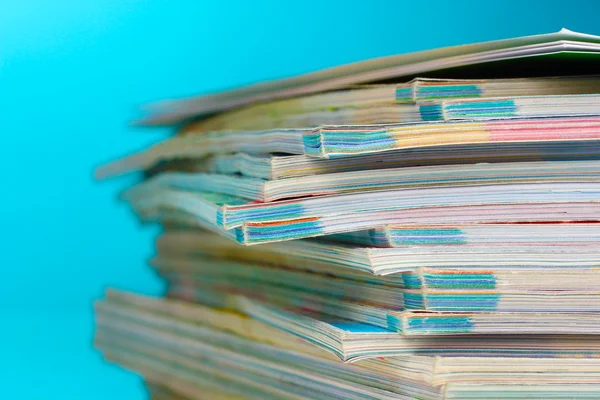 Pila di riviste su sfondo blu — Foto Stock