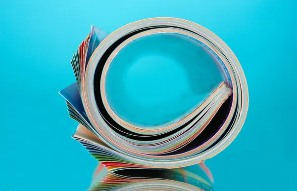 Revistas enroladas em fundo azul — Fotografia de Stock