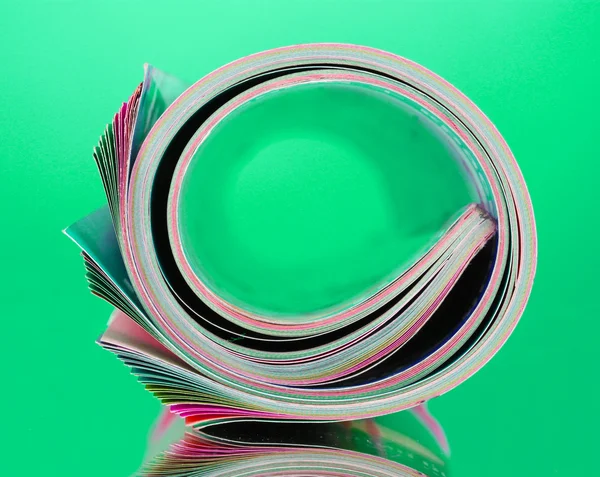 stock image Rolled up magazines on green background