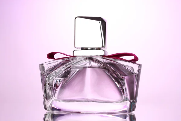 Damenparfüm in schöner Flasche auf rosa Hintergrund — Stockfoto