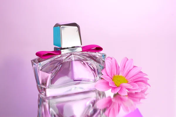 Perfume de mujer en hermosa botella y flor sobre fondo rosa —  Fotos de Stock