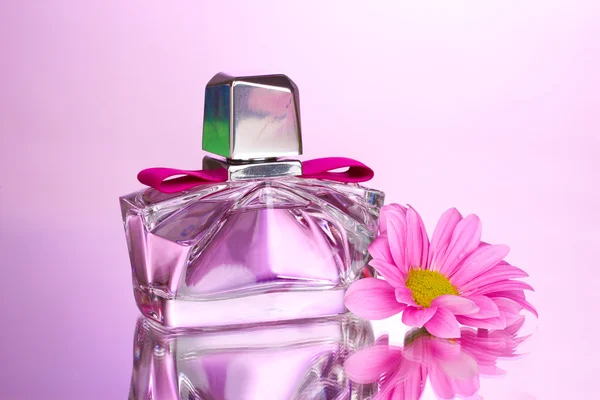 아름 다운 병에 꽃 분홍색 배경에 여자의 향수 — 스톡 사진