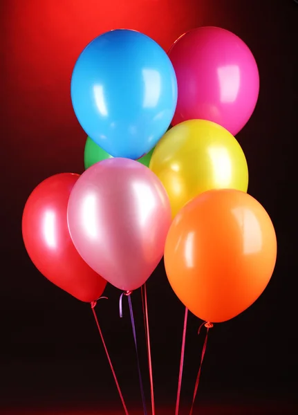 Heldere ballonnen op rode achtergrond — Stockfoto
