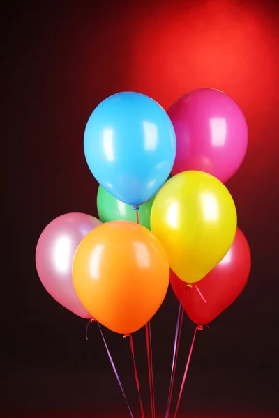 Ljusa ballonger på röd bakgrund — Stockfoto
