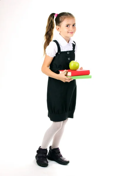 Schönes kleines Mädchen in Schuluniform, Bücher und Apfel isoliert auf weiß — Stockfoto