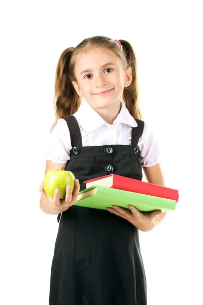 Linda menina em uniforme escolar, livros e maçã isolada em branco — Fotografia de Stock
