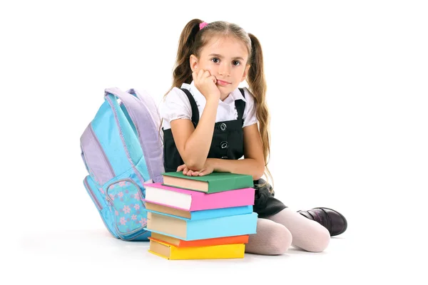 Красивая маленькая девочка, книги и рюкзак изолированы на белом — стоковое фото