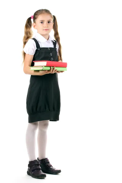 Linda menina em uniforme escolar e livros isolados em branco — Fotografia de Stock