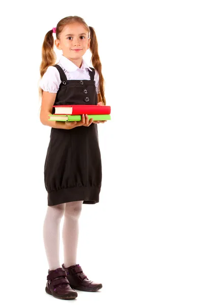 Vacker liten flicka i skoluniform och böcker isolerad på vit — Stockfoto