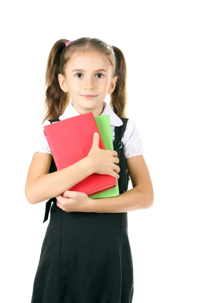 Vacker liten flicka i skoluniform och böcker isolerad på vit — Stockfoto