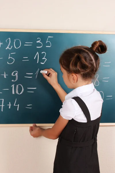 Güzel küçük bir kız sınıfta tahtaya yazma — Stok fotoğraf