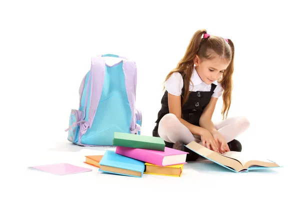 Schöne kleine Mädchen, Bücher und einen Rucksack isoliert auf weiß — Stockfoto