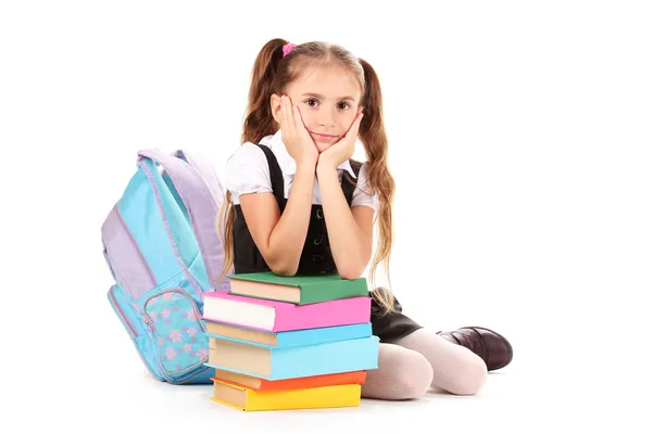 Красива маленька дівчинка, книги і рюкзак ізольовані на білому — стокове фото
