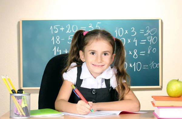 Маленькая школьница в классе рядом с доской — стоковое фото