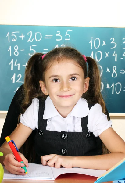 Pequena criança em sala de aula perto de quadro-negro — Fotografia de Stock