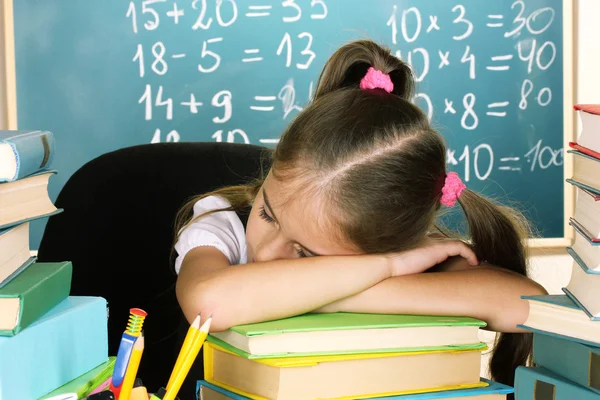 Weinig schoolmeisje slapen in de klas in de buurt van blackboard — Stockfoto