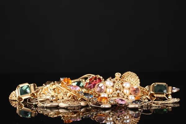 Various gold jewellery on black background — Stock Photo, Image