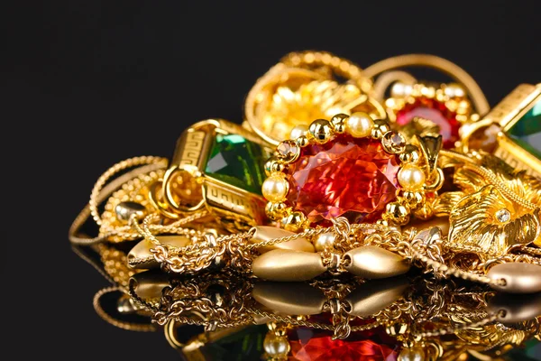Různé zlaté šperky na černém pozadí — Stock fotografie